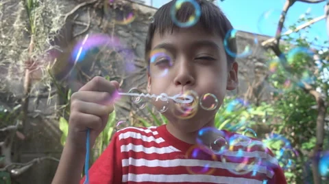 Little boy blowing bubble soap close up slow motion HD Stockbeeldmateriaal 65833618