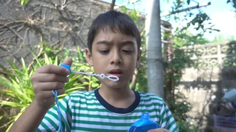 Little boy blowing bubble soap close up slow motion HD Stockbeeldmateriaal 65836372