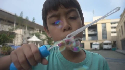 Little boy blowing bubble soap slow motion HD Stock video Stockbeeldmateriaal 74617213