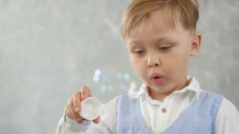 Little boy blowing soap bubbles Stock Footage 77396990