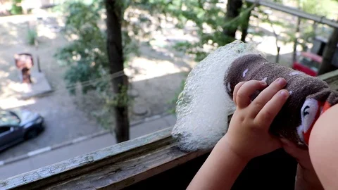 A little boy blowing soap bubbles in on the balcony in the apartment. Unusual an Stock Footage 94829803