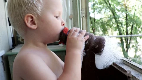 A little boy blowing soap bubbles in on the balcony in the apartment. Unusual an Vidéo 94829914