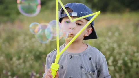A little boy blowing soap bubbles in the park Stock Footage 134467568