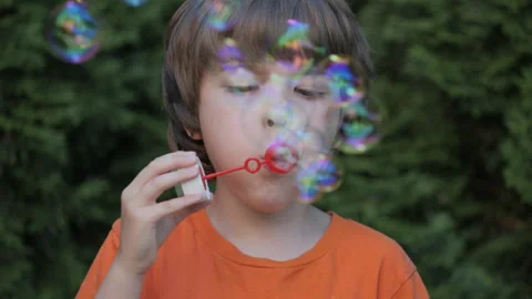 Little Boy Blowing Soap Bubbles Having Fun Playing Outside, Child Innocence.. Video stock 303936239