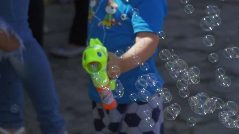 Little boy blows bubbles from a gun Stock Footage 82406146