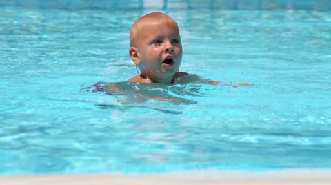 Little boy in blue pool dive under the water in turn 動画素材 35234184