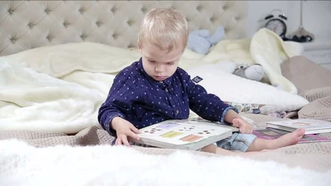 Little boy is browsing a book. FULL HD. Video stock 73964268