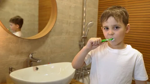 Little boy brushing his teeth and making faces at the camera Stock Footage 128779106