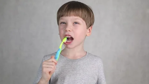Little boy brushing his teeth on white background Stock Footage 236449690