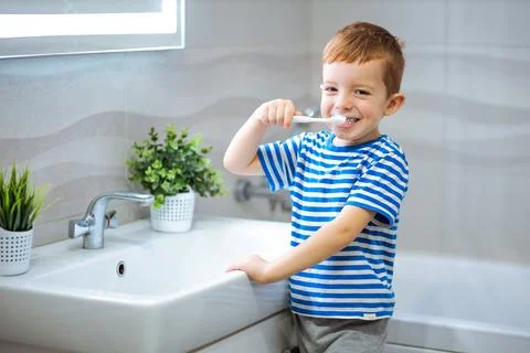 Little boy brushing teeth in bathroom Stock Photos