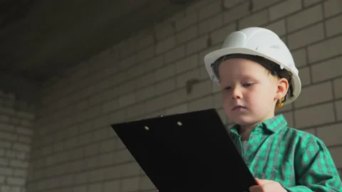 A little boy builder checks the work done according to the plan of the drawings Stock Footage 238090336