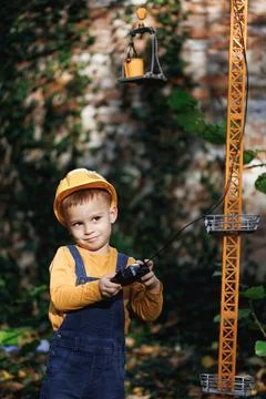 Little boy builder in uniform working on construction site. Child future Stock Photos