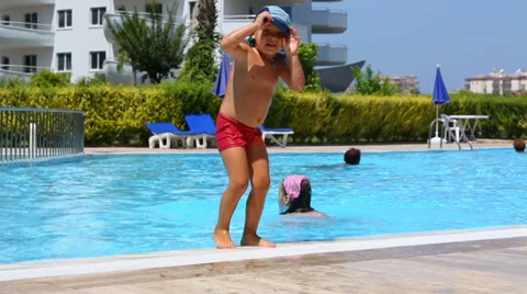 Little boy in cap dive in pool with swimming sister 動画素材 35234186