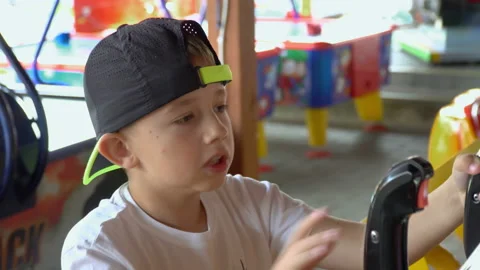 A little boy in a cap on his head plays a television game. He smiles, enjoys and Video stock 87979098