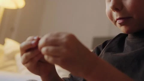 A little boy carefully assembles a construction set at home. Stock Footage 252382413