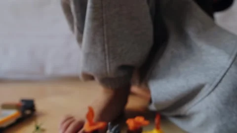 A little boy carefully assembles a construction set at home. Stock Footage 252382445