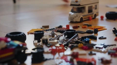 A little boy carefully assembles a construction set at home. Stock Footage 252382469