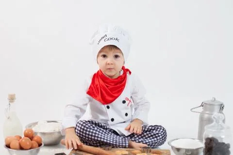 Little boy with chefs hat, preparing cookies Stock Photos