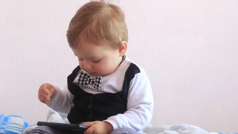Little boy, child, eats cookies and holds a mobile phone Stock Footage 201325804