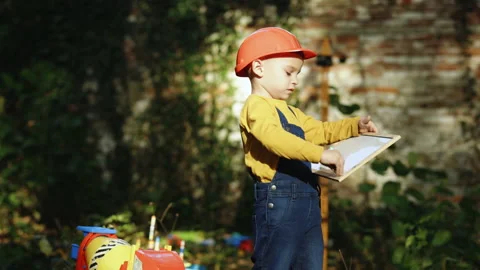 Little boy child future engineer builder architect with safety helmet with Stock Footage 229736298