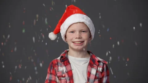 Little boy in a christmas cap throwing up confetti Stock Footage 68376823