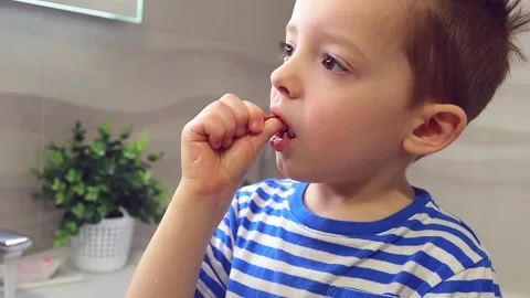 A little boy cleans between his teeth a brush, at home in the bathroom Stock Footage 149701299