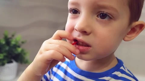 A little boy cleans the space between his teeth with a professional brush, at Stock Footage 149701394