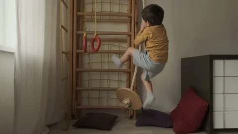 Little boy climbs the rope to the ceiling and goes down. Stock Footage 149992302