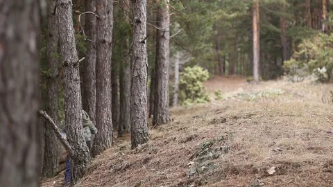 Little boy coming down the hillside into forest Video stock 73018899