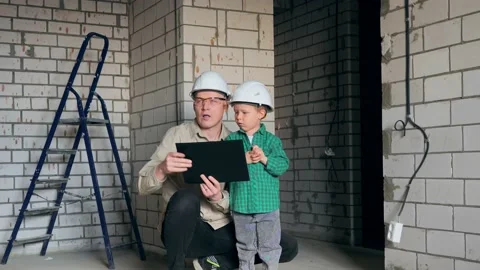 A little boy on a construction site inspects his room with his dad Stock Footage 238079018