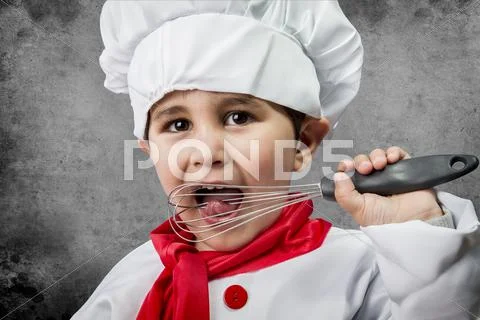A little boy cook in uniform over vintage background Stock Photos