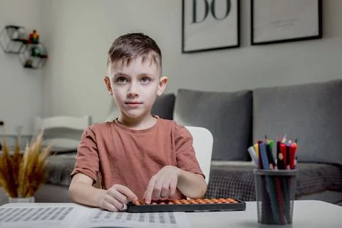 Little boy Counting with help an abacus. Mental arithmetic, brain development Foto stock