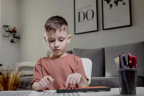 Little boy Counting with help an abacus. Mental arithmetic, brain development Foto stock