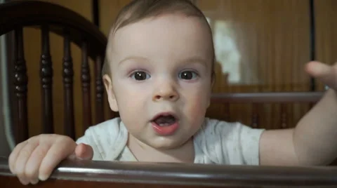 Little boy in a crib and pulls hands to the camera Vídeos de archivo 62344653