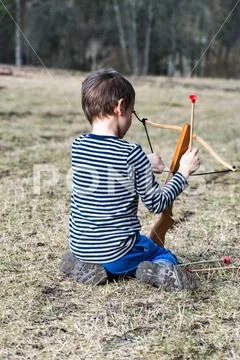 Little boy with a crossbow III Stock Photos