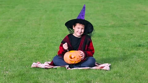 Little boy cuts out pumpkin on a Halloween Stock Footage 68100017