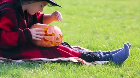 Little boy cuts out pumpkin on a Halloween Stock Footage 68100083