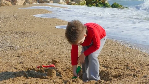 Little boy digging sand on the beach Stock Footage 78595085