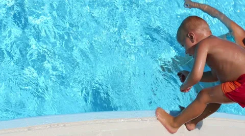 Little boy dive into the pool for toy and gets out to edge 動画素材 35234290