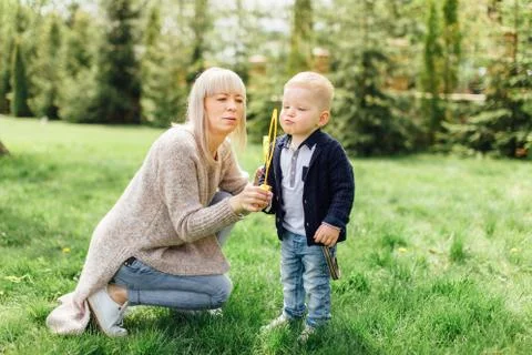 Little boy do bubbles with his mother at park Stock Photos