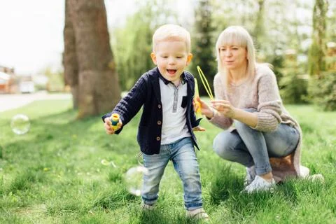 Little boy do bubbles with his mother at park Stock Photos