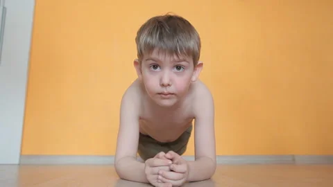 The little boy does exercises, plays sports is in the strap on the hands Stock Footage 106381229