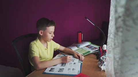 Little boy does homework, writes useful information. Slow Motion. Stock Footage 132033458