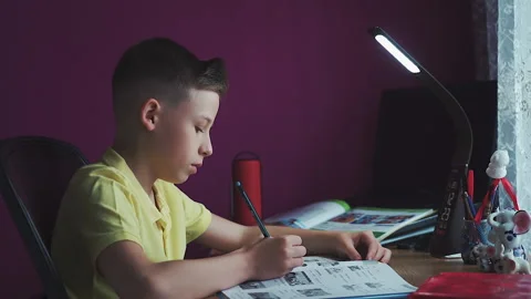 Little boy does homework, writes useful information. Slow Motion. Video stock 132033601