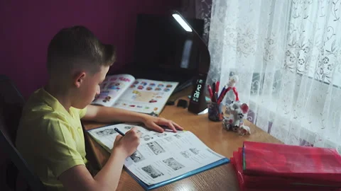 Little boy does homework, writes useful information. Slow Motion. Stock Footage 132033746