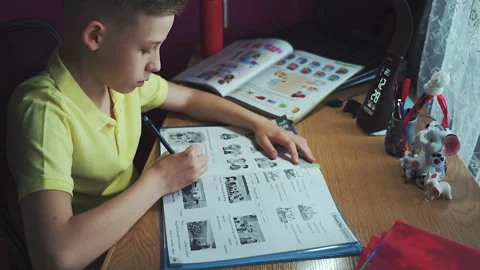 Little boy does homework, writes useful information. Slow Motion. Stock Footage 132033795