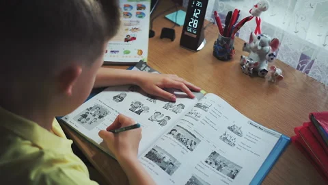 Little boy does homework, writes useful information. Slow Motion. Video stock 132033906