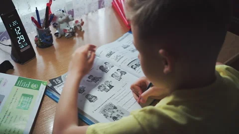 Little boy does homework, writes useful information. Slow Motion. Video stock 132034029
