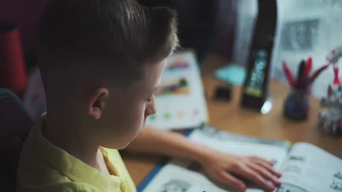 Little boy does homework, writes useful information. Slow Motion. Video stock 132034305