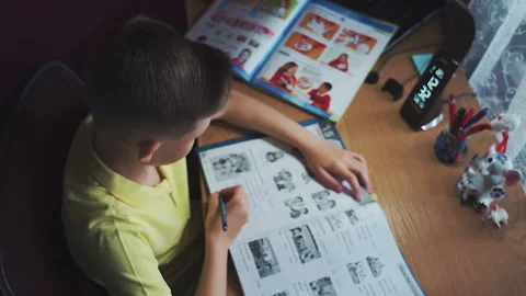 Little boy does homework, writes useful information. Slow Motion. Video stock 132034324